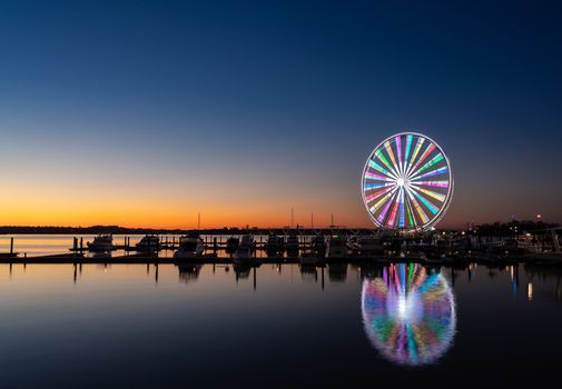 Illuminated ferris wheel at National Harbor near the nation capital of Washington DC at sunset