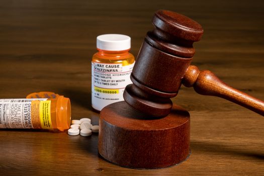 Oxycodone is the generic name for opoid pain killing tablets. Prescription bottle for pills and tablets with judge's gavel for court decision