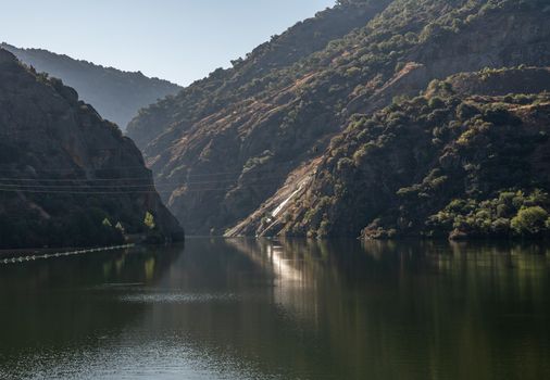 River Douro flowing through narrow gorge with rocky slopes on the banks in Portugal near Pinhao