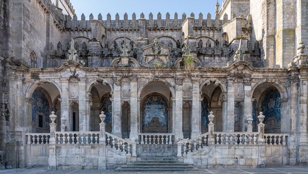 Stone steps, carvings and ceramic scenes in the side portico of the old Cathedral or Se in Porto