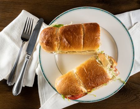 From above view of crusty bread and bacon, lettuce and tomato takeout food plated at home with napkin