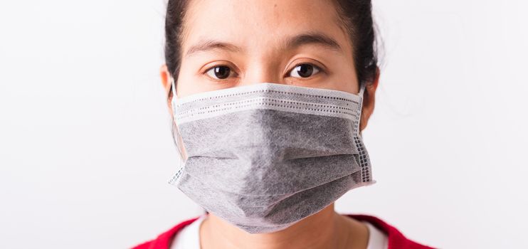 Asian adult woman wearing red shirt and face mask protective against coronavirus or COVID-19 virus or filter dust pm2.5 and air pollution she looking camera, studio shot isolated white background