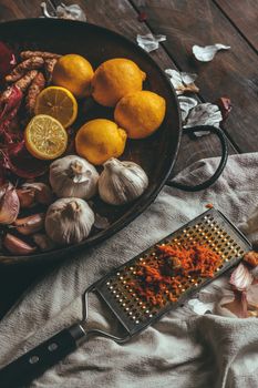 Paella with onion, garlic, lemon and grated turmeric on a rustic wooden table