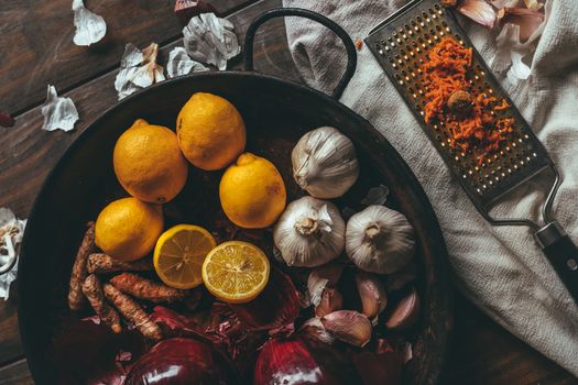 Paella with onion, garlic, lemon and grated turmeric on a rustic wooden table