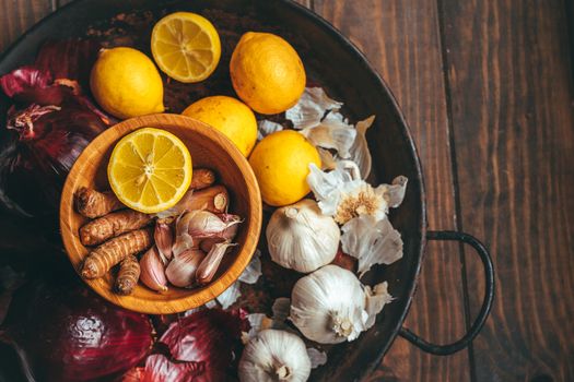 Paella with onion, turmeric, garlic and lemon on a wooden table in a rustic tone