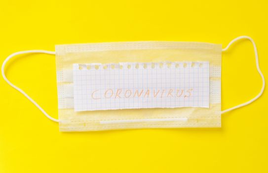 Coronavirus medical mask on yellow background. Surgical protective mask. Health care.