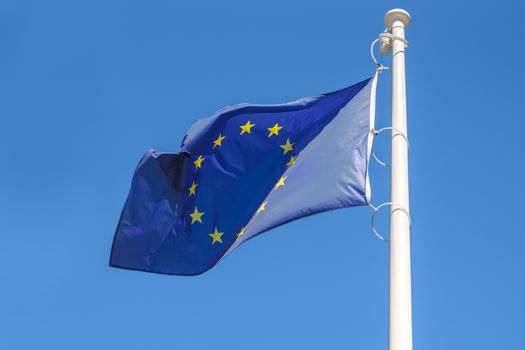 Flag of the European Union waving in the wind on a blue sky background