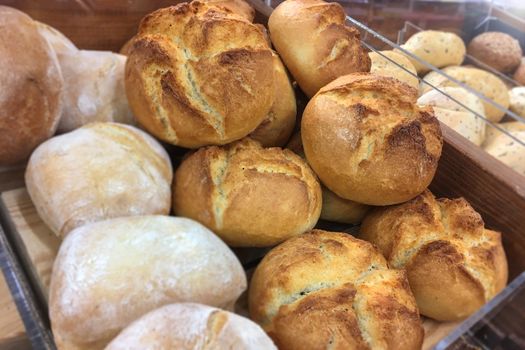 Different types of fresh and crispy baked rolls from the bakery for sale in the shop