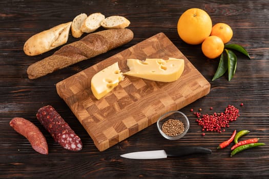 Sausage, cheese and bread on wooden cutting board