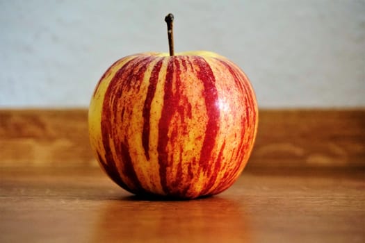 Photo of a single apple on a wooden table