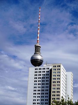 Berlin television tower behind house in front of cloudy sky