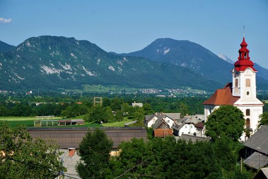 Saint John the Baptist Church Zasip, Slovenia in front of mountain panorama