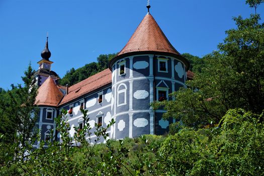 Blue castle and green trees in Olimje, Slovenia