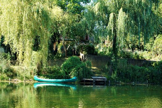 Boat floating on the Krka river in Kostanjevica na Krki, Slovenia