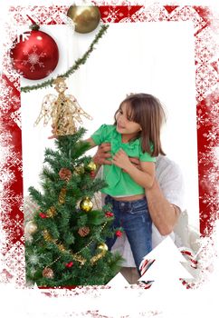 Attentive father holding her daughter to decorate the christmas tree against christmas themed frame