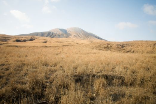 Mount Aso and Kusasenri in winter. covered by golden yellow grassland - Kumamoto, Japan