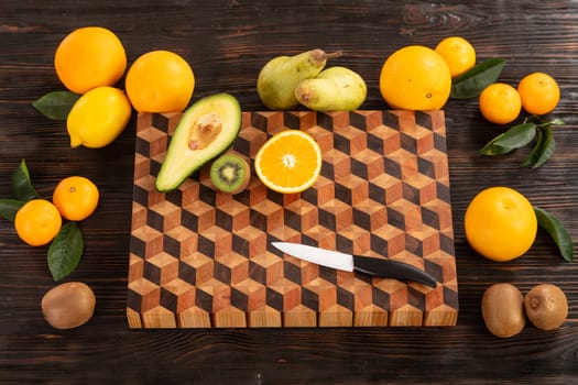 Juicy whole and sliced fruit with a knife on a wooden cutting board