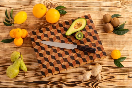 Juicy whole and sliced fruit with a knife on a wooden cutting board