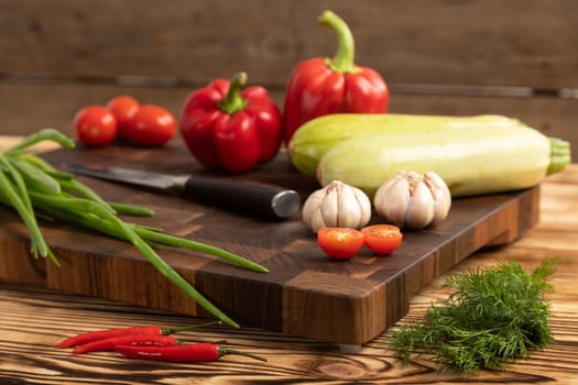 Fresh vegetables and greens on wooden cutting board