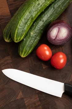 Fresh vegetables and greens on wooden cutting board