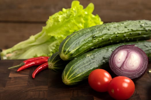 Fresh vegetables and greens on wooden cutting board