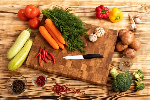 Fresh vegetables and greens on wooden cutting board