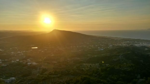 Sunset over hill and village in Greece