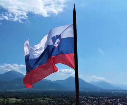 Slovenian flag over lake Bled in front of Triglav mountains