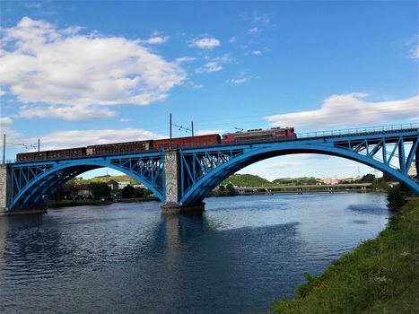 Blue bridge and train over the Drava river in Maribor, Slovenia