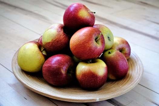 Apples in a bowl on wooden floor still life