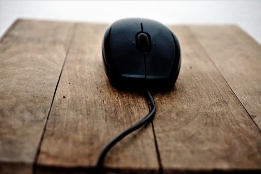 Black mouse and wire on wooden table