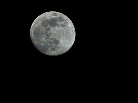 A pale moon on the black night sky