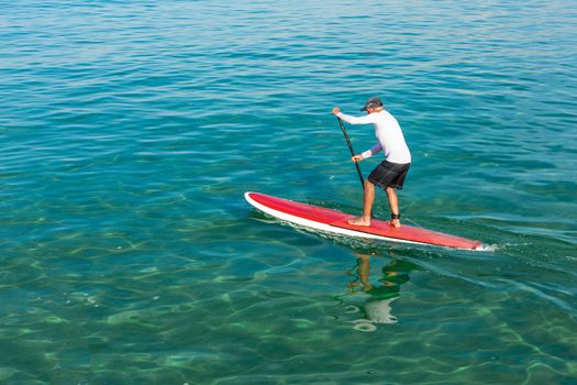 A senior man practicing paddle on a beautiful sunny day