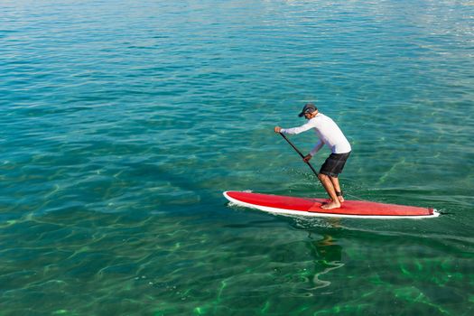 A senior man practicing paddle on a beautiful sunny day