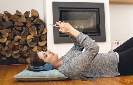 Beautiful woman lying on the floor and listen music 