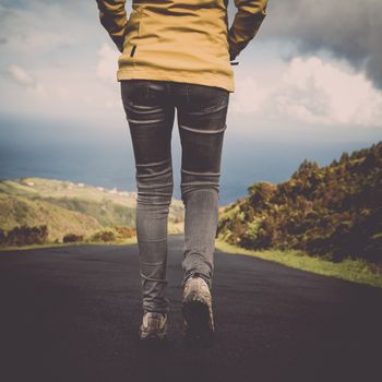 Young traveller woman walking by the road