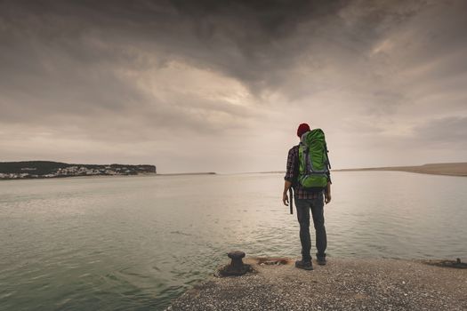 Man Traveling Backpack enjoying the beautiful view of the lake