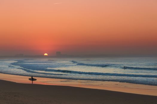 Surfer at sunset checking the waves