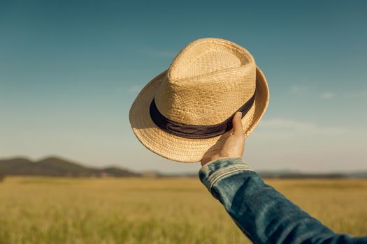 Female hand holding  a straw hat 