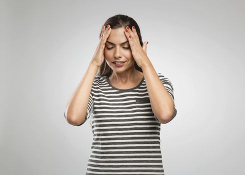 Beautiful woman with hands on head felling a headache