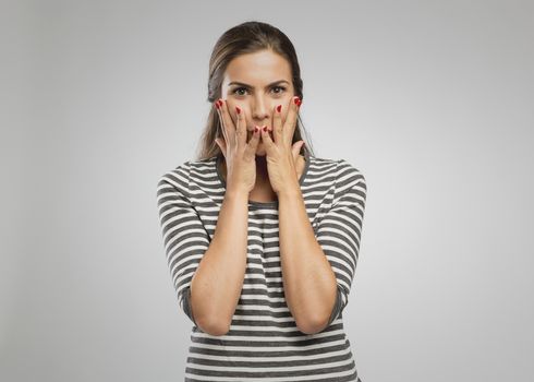 Surprised girl covering mouth with her hands