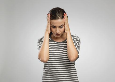 Beautiful woman with hands on head worried with something