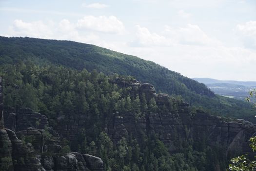 Beautiful sandstone rock formations in front of green forest in Saxon Switzerland, Germany