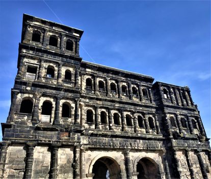 Impressive porta nigra gate in front of blue sky in Trier, Germany