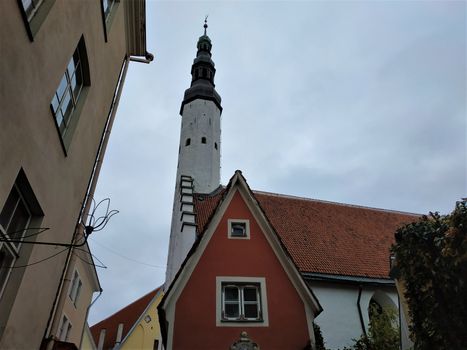 Tower of the Church of the Holy Spirit with red house in Tallinn, Estonia