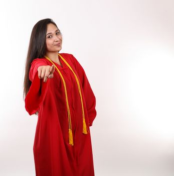A young graduate points her finger at the camera.