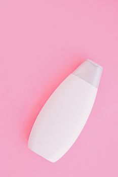 Blank label shampoo bottle or shower gel on pink background, beauty product and body care cosmetics, flatlay