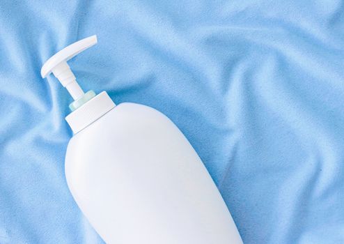 Blank label bottle of antibacterial liquid soap and hand sanitizer mockup on blue silk, hygiene product and health care, flatlay