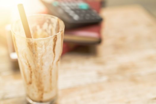 empty cup of iced mocha coffee on wooden table background.