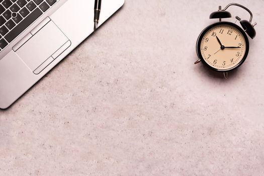 computer laptop with black clock on working table flat lay composition top view  with copy space